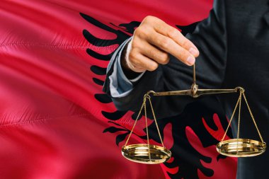 Arnavutça Yargıç adaletin terazisi altın arka plan bayrak sallayarak Arnavutluk ile tutuyor. Eşitlik Tema ve yasal kavram.