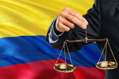 Kolombiya Yargıç adaletin altın terazisi sallayarak bayrak arka plan Kolombiya ile tutuyor. Eşitlik Tema ve yasal kavram.