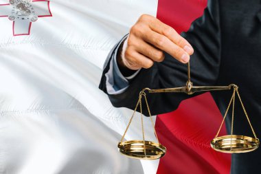 Malta Yargıç adaletin altın terazisi ile Malta bayrağı arka plan sallayarak tutuyor. Eşitlik Tema ve yasal kavram.