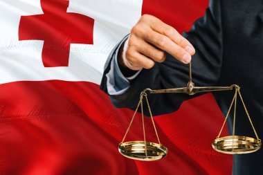 Tongan Yargıç adaletin terazisi altın arka plan bayrak sallayarak Tonga ile tutuyor. Eşitlik Tema ve yasal kavram.