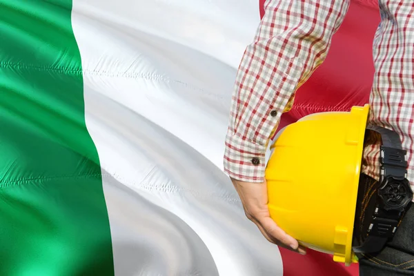 意大利工程师拿着黄色安全帽 挥舞着意大利国旗背景 建筑和建筑理念 — 图库照片