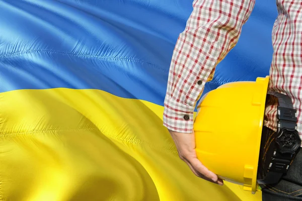 Ingeniero Ucraniano Está Sosteniendo Casco Seguridad Amarillo Con Ondear Fondo —  Fotos de Stock