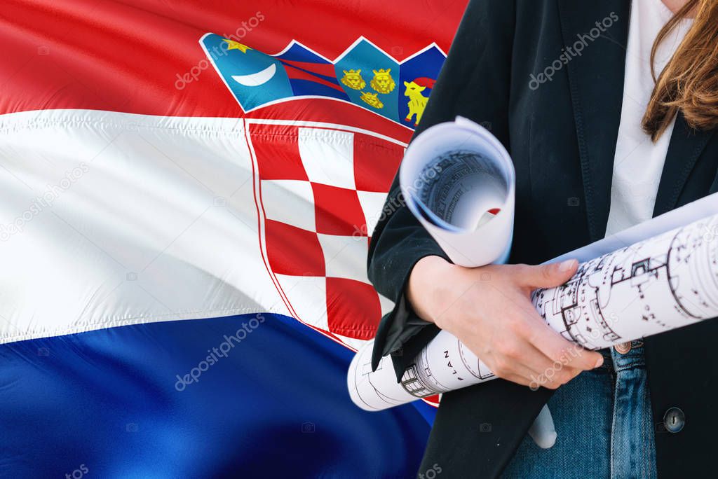 Croatian Architect woman holding blueprint against Croatia waving flag background. Construction and architecture concept.