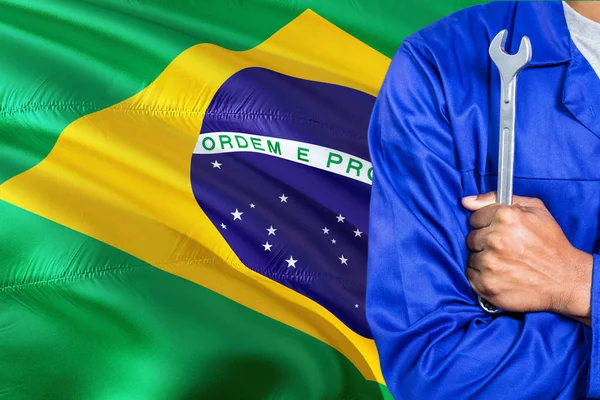 Braziliaanse Monteur Blauwe Uniform Houdt Moersleutel Tegen Achtergrond Van Vlag — Stockfoto