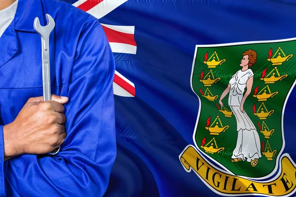 身穿蓝色制服的机械师拿着扳手对着挥舞英属维尔京群岛国旗的背景 交叉武器技术员 — 图库照片