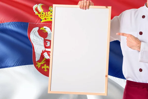 Serbski Kucharz Trzyma Pustej Tablicy Menu Tle Flaga Serbii Gotować — Zdjęcie stockowe