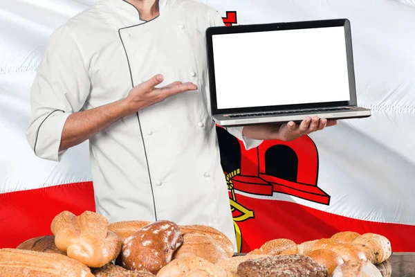 Baker Holding Laptop Gibraltar Flag Breads Background Chef Wearing Uniform — Stock Photo, Image