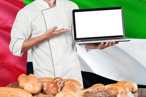 Baker Segurando Laptop Bandeira Dos Emirados Árabes Unidos Fundo Pães — Fotografia de Stock