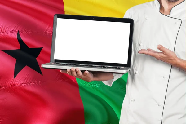 Chef Sosteniendo Portátil Con Pantalla Blanco Guinea Bissau Fondo Bandera — Foto de Stock