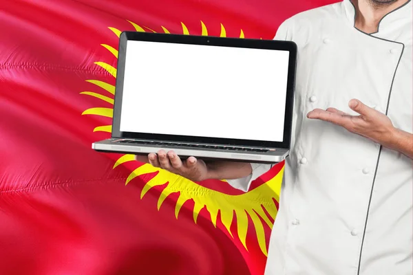 Chef Kirguiso Sostiene Computadora Portátil Con Pantalla Blanco Fondo Bandera — Foto de Stock