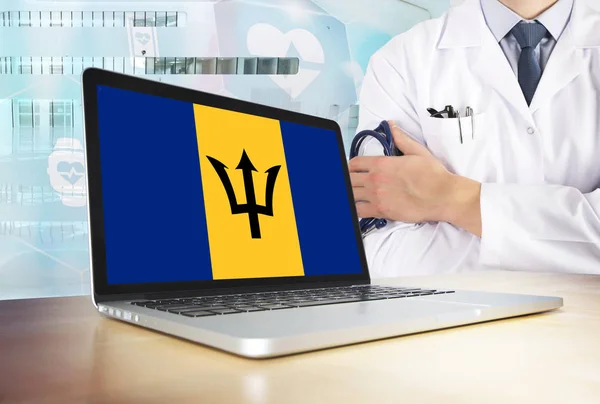 Barbados healthcare system in tech theme. Barbadian flag on computer screen. Doctor standing with stethoscope in hospital. Cryptocurrency and Blockchain concept.