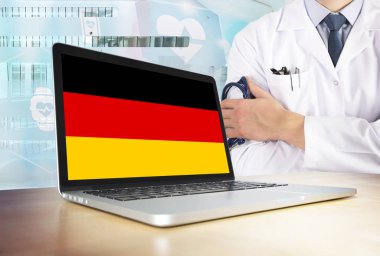 Almanya teknik Tema sağlık sisteminde. Alman bayrağı bilgisayar ekranında. Hastanede stetoskop ile ayakta doktor. Cryptocurrency ve Blockchain kavramı.