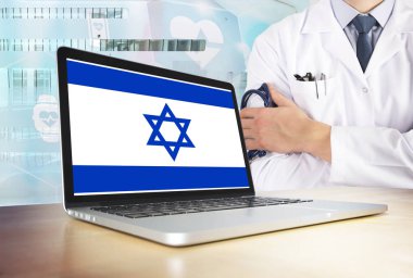 İsrail teknoloji tema sağlık sisteminde. İsrail bayrağı bilgisayar ekranında. Hastanede stetoskop ile ayakta doktor. Cryptocurrency ve Blockchain kavramı.