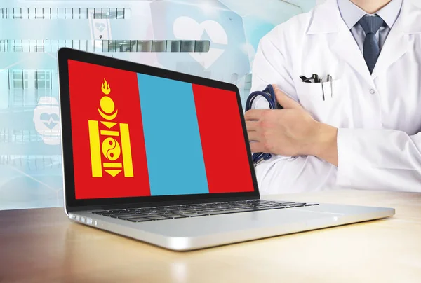 Mongolia healthcare system in tech theme. Mongolian flag on computer screen. Doctor standing with stethoscope in hospital. Cryptocurrency and Blockchain concept.