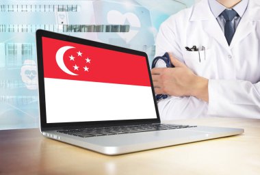Singapur sağlık sistemi teknoloji tema. Singapurlu bayrak bilgisayar ekranında. Hastanede stetoskop ile ayakta doktor. Cryptocurrency ve Blockchain kavramı.