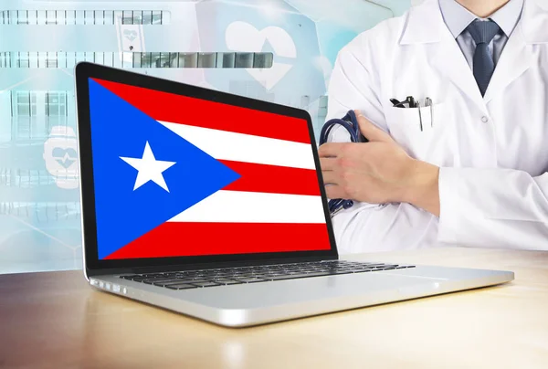 Puerto Rico healthcare system in tech theme. Flag on computer screen. Doctor standing with stethoscope in hospital. Cryptocurrency and Blockchain concept.