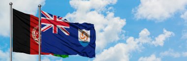 Afganistan ve Anguilla bayrağı birlikte beyaz bulutlu mavi gökyüzüne karşı rüzgarda sallayarak. Diplomasi kavramı, uluslararası ilişkiler.