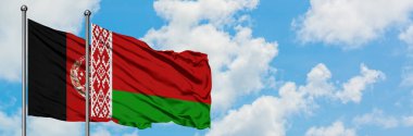 Afganistan ve Beyaz Rusya bayrağı birlikte beyaz bulutlu mavi gökyüzüne karşı rüzgarda sallayarak. Diplomasi kavramı, uluslararası ilişkiler.