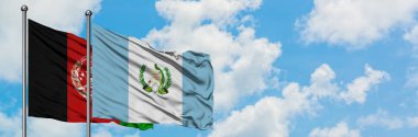 Afganistan ve Guatemala bayrağı birlikte beyaz bulutlu mavi gökyüzüne karşı rüzgarda sallayarak. Diplomasi kavramı, uluslararası ilişkiler.