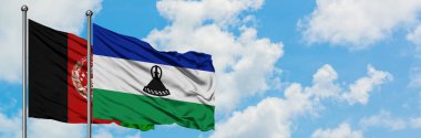 Afganistan ve Lesotho bayrağı birlikte beyaz bulutlu mavi gökyüzüne karşı rüzgarda sallayarak. Diplomasi kavramı, uluslararası ilişkiler.