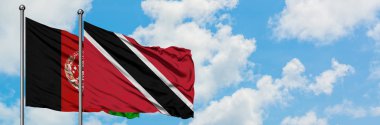 Afganistan ve Trinidad ve Tobago bayrağı birlikte beyaz bulutlu mavi gökyüzüne karşı rüzgarda sallayarak. Diplomasi kavramı, uluslararası ilişkiler.