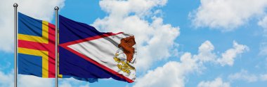 Aland Adaları ve Amerikan Samoa sıcağı birlikte beyaz bulutlu mavi gökyüzüne karşı rüzgarda sallayarak. Diplomasi kavramı, uluslararası ilişkiler.
