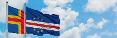 Aland Adaları ve Cape Verde bayrağı birlikte beyaz bulutlu mavi gökyüzüne karşı rüzgarda sallayarak. Diplomasi kavramı, uluslararası ilişkiler.