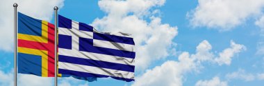 Aland Adaları ve Yunanistan bayrağı birlikte beyaz bulutlu mavi gökyüzüne karşı rüzgarsal sallayarak. Diplomasi kavramı, uluslararası ilişkiler.