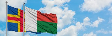 Aland Adaları ve Madagaskar bayrağı birlikte beyaz bulutlu mavi gökyüzüne karşı rüzgarda sallayarak. Diplomasi kavramı, uluslararası ilişkiler.