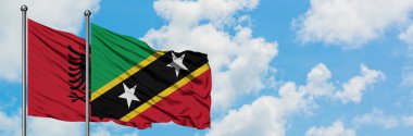 Arnavutluk ve Saint Kitts ve Nevis bayrağı birlikte beyaz bulutlu mavi gökyüzüne karşı rüzgarda sallayarak. Diplomasi kavramı, uluslararası ilişkiler.