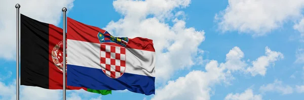 Bandera de Afganistán y Croacia ondeando en el viento contra el cielo azul nublado blanco juntos. Concepto diplomático, relaciones internacionales . — Foto de Stock