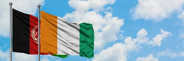 Afghanistan and Cote D'Ivoire flag waving in the wind against white cloudy blue sky together. Diplomacy concept, international relations. — Stock Photo, Image