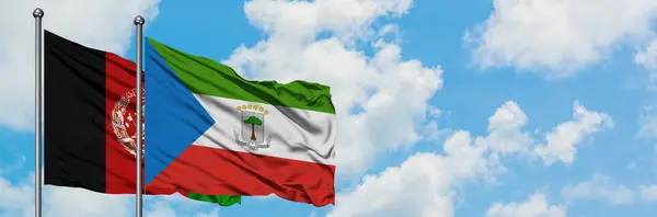 Bandera de Afganistán y Guinea Ecuatorial ondeando en el viento contra el cielo azul nublado blanco juntos. Concepto diplomático, relaciones internacionales . — Foto de Stock