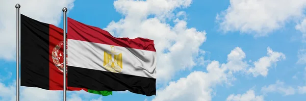 Bandera de Afganistán y Egipto ondeando en el viento contra el cielo azul nublado blanco juntos. Concepto diplomático, relaciones internacionales . — Foto de Stock