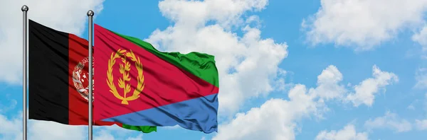 Bandera de Afganistán y Eritrea ondeando en el viento contra el cielo azul nublado blanco juntos. Concepto diplomático, relaciones internacionales . — Foto de Stock