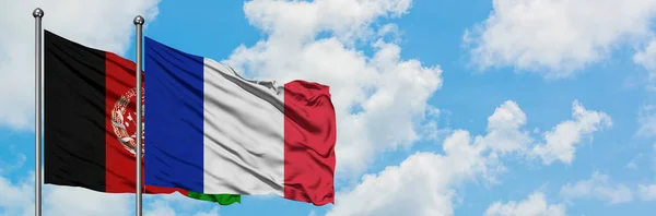 Bandera de Afganistán y Francia ondeando en el viento contra el cielo azul nublado blanco juntos. Concepto diplomático, relaciones internacionales . — Foto de Stock