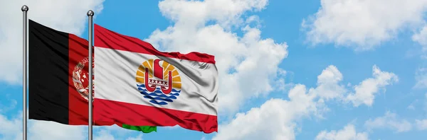 Afghanistan and French Polynesia flag waving in the wind against white cloudy blue sky together. Diplomacy concept, international relations. — Stock Photo, Image