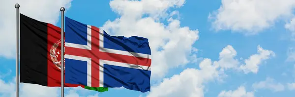 Bandera de Afganistán e Islandia ondeando en el viento contra el cielo azul nublado blanco juntos. Concepto diplomático, relaciones internacionales . — Foto de Stock