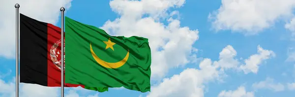 Bandera de Afganistán y Mauritania ondeando en el viento contra el cielo azul nublado blanco juntos. Concepto diplomático, relaciones internacionales . — Foto de Stock