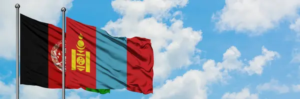 Bandera de Afganistán y Mongolia ondeando en el viento contra el cielo azul nublado blanco juntos. Concepto diplomático, relaciones internacionales . — Foto de Stock