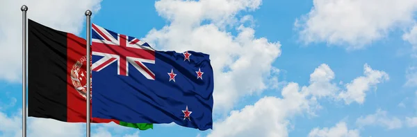 阿富汗和新西兰国旗在风中飘扬，与白云蓝天相一起。外交概念、国际关系. — 图库照片