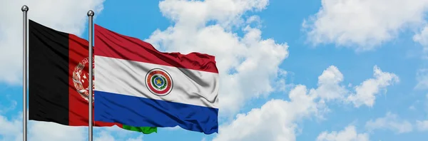 阿富汗和巴拉圭国旗在风中飘扬，白云蓝天相聚。外交概念、国际关系. — 图库照片