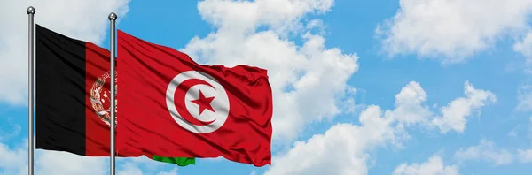 阿富汗和突尼斯国旗在风中飘扬，白云蓝天相聚。外交概念、国际关系. — 图库照片