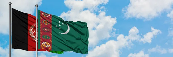 Afghánistán a Turkmenistán vlají ve větru proti bíle zatažené modré obloze. Diplomacie, mezinárodní vztahy. — Stock fotografie