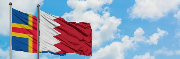 阿兰群岛和巴林国旗在风中飘扬，白云蓝天相聚。外交概念、国际关系. — 图库照片