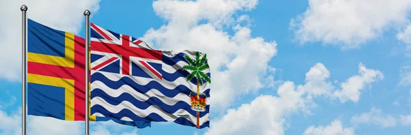 Aland Islands a britské teritorium Indického oceánu mávajících větrem proti bíle zatažené modré obloze. Diplomacie, mezinárodní vztahy. — Stock fotografie