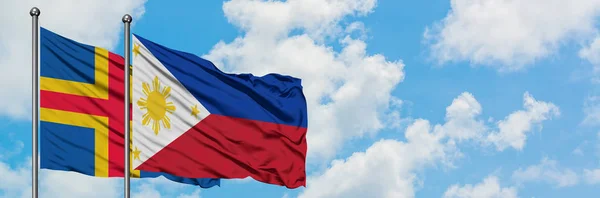 Флаг Аландских островов и Филиппин размахивает ветром против белого облачно-синего неба вместе. Концепция дипломатии, международные отношения . — стоковое фото