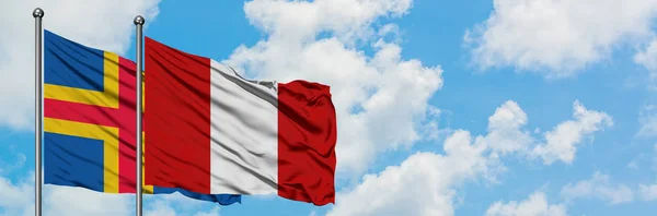 Alandské ostrovy a Peruánská vlajka mávali větrem ve větru proti bíle zatažené modré obloze. Diplomacie, mezinárodní vztahy. — Stock fotografie