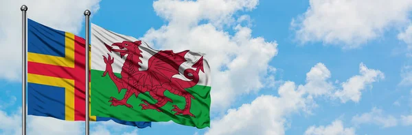 阿兰群岛和威尔士国旗在风中飘扬，与白云蓝天相一起。外交概念、国际关系. — 图库照片