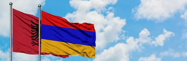 Albánie a Arménská vlajka mávali ve větru proti bíle zatažené modré obloze. Diplomacie, mezinárodní vztahy. — Stock fotografie